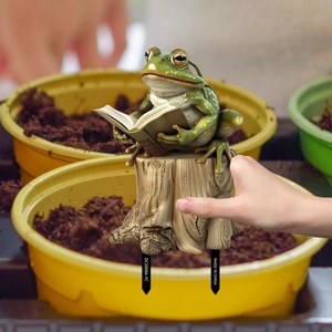 Detailed view of creative resin frog garden stake reading a book for outdoor decor