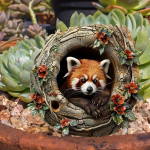 Creative garden decor featuring a resin red panda sitting in a hollow tree trunk stake