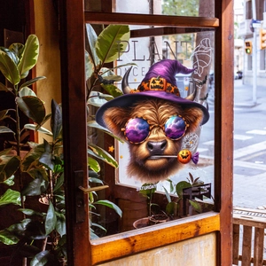 Halloween highland cow window sticker with wizard hat on glass pane with outdoor background