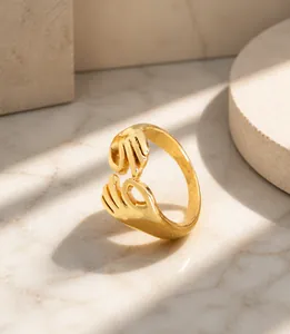 Detailed view of gold embrace hands ring featuring a creative hugging hands design