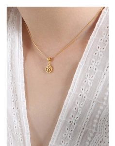 Macro shot of gold-plated titanium necklace with hollow round double happiness pendant