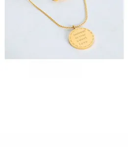 Close-up of golden necklace with a round tag pendant engraved with sweet love message