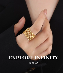 Detail of gold hollow honeycomb ring with micro-pave crystals on black fabric background