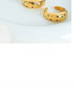 Detailed view of gold plated thick rings featuring colorful inset stones in a retro style