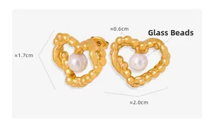 Macro detail of gold textured heart earrings with glass beads and precise dimensions