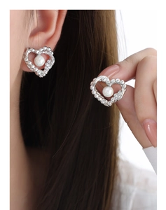 Detailed view of silver heart pearl earrings featuring intricate beaded texture and white pearl