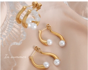 Vue rapprochée de boucles d'oreilles dorées avec perles brillantes sur tissu