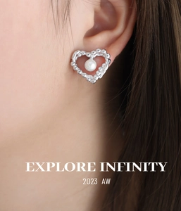 Detail of silver heart earrings with pearl centers on a model for an elegant look