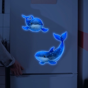Luminous blue whale wall stickers glowing in the dark on a white refrigerator surface