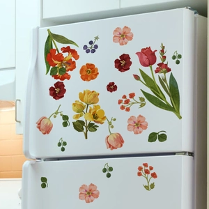 Gros plan de stickers muraux fleurs et feuilles aquarelle sur un réfrigérateur blanc