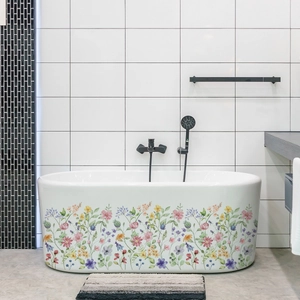 Détail d'une baignoire blanche en îlot avec des motifs floraux colorés autocollants
