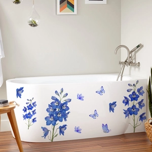 Détail de stickers de fleurs bleues et papillons sur une surface de baignoire blanche