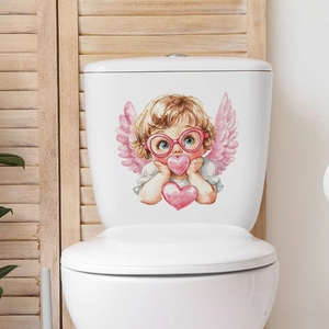 Close-up of baby angel toilet sticker with pink wings and heart decals on white ceramic