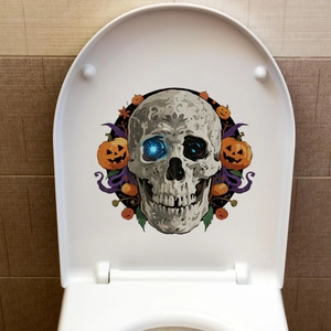 Sticker d'Halloween crâne et citrouille lumineux sur un abattant de WC blanc