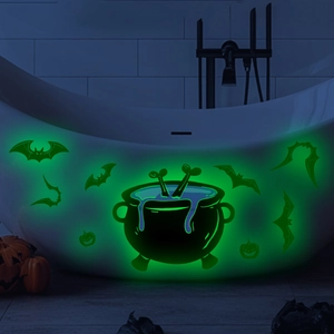 Leuchtende Halloween-Aufkleber mit grünem Kürbis und Hexenkessel an einer Badewanne