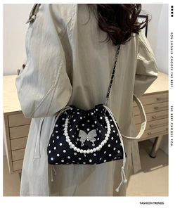 Polka dot canvas bucket bag detail with pearl handle and silver butterfly charm