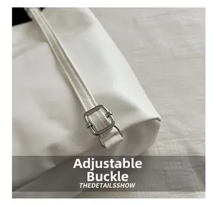 Macro detail of the white leather tote with adjustable silver buckle and premium stitching