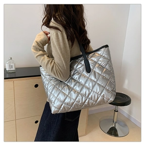 Détail du grand sac cabas matelassé argenté avec fines lanières noires sur modèle