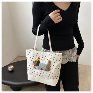 Detailed close-up of a white tote bag with colorful polka dots and a plush dog patch