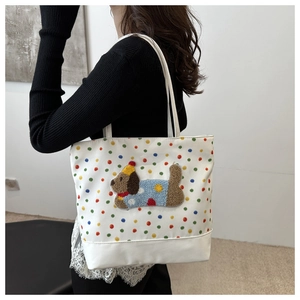 Detail of white polka dot tote bag featuring a cute puppy embroidery and colorful patterns