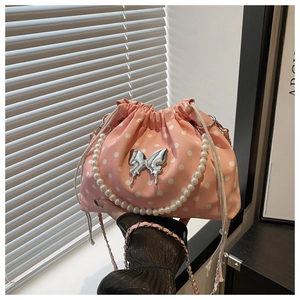 Detail of pink polka dot bucket bag with silver butterfly buckle and pearl handle