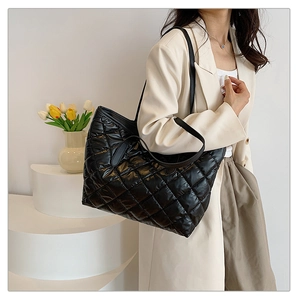 Sac fourre-tout matelassé noir chic avec texture rembourrée porté par un mannequin femme