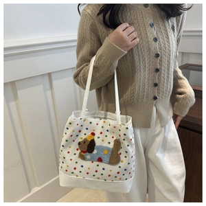 Detailed embroidery of a cute puppy with colorful polka dots on a white tote bag
