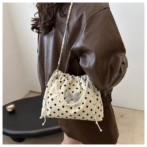 Polka dot bucket bag with silver butterfly charm and pearl strap shown on model