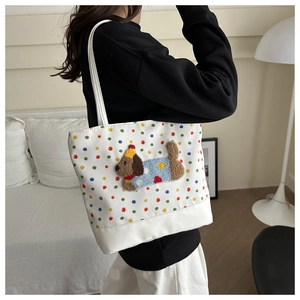 Close-up of white tote bag with colorful polka dots and 3D embroidered puppy patch