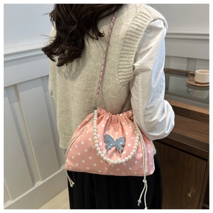 Detail of pink polka dot bucket bag with pearl handle and butterfly charm