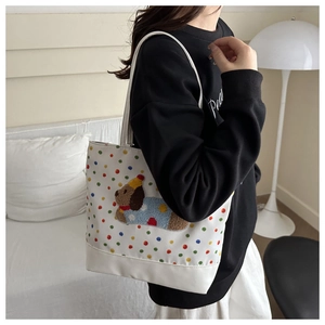 Detail of cute puppy 3D plush embroidery on polka dot canvas tote bag with party hat