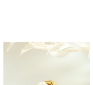 Détail de boucles d'oreilles torsadées en or avec perle brillante et texture élégante