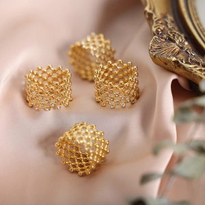 Elegant gold honeycomb hollow rings with zircon crystals on champagne silk background