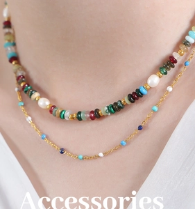 Gros plan du collier double rang avec perles colorées et chaîne dorée
