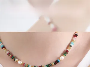 Détail d'un collier de pierres précieuses colorées et perles d'eau douce sur modèle