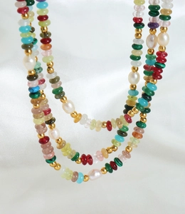 Gros plan d'un collier multi-rangs avec pierres colorées et perles d'eau douce sur soie