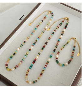 Détail d'un ensemble de colliers perlés colorés et bracelet en perles avec fermoirs inox