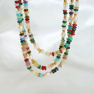 Collier multicouche en pierres naturelles et perles d'eau douce sur tissu en soie blanche