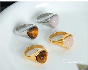 Detail of four titanium steel rings with triangle tiger eye and rose quartz in a set