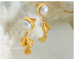 Detailed close-up of French baroque pearl earrings with textured golden leaf pendants