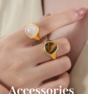 Close-up of gold-plated signet rings featuring triangular tiger eye and pink quartz stones