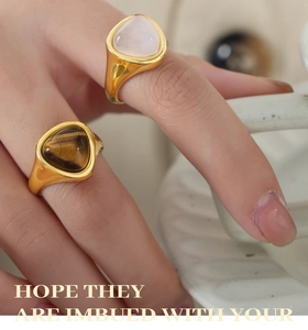 Detail of gold plated titanium rings with triangular rose quartz and tiger eye stones
