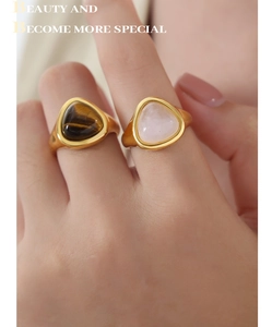 Detailed view of gold plated titanium rings with triangular tiger eye and rose quartz stones