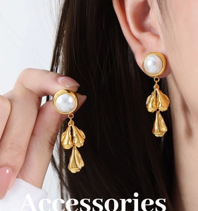 Close-up of gold-plated tassel earrings with white pearls on model for retro elegant style