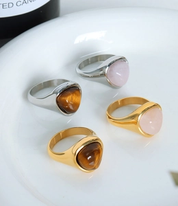Detail of gold and silver titanium rings with triangular tiger eye and rose quartz stones