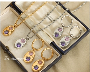 Détails de pendentifs ovales avec gravure d'étoiles et zircons sur chaînes torsadées