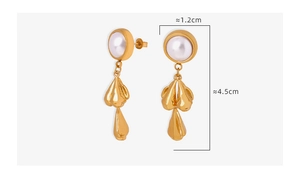 Detail of elegant gold earrings with white pearl and irregular liquid metal tassel pendant