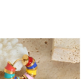 Macro d'une boucle d'oreille créole en titane doré avec design émail multicolore