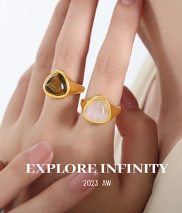 Macro shot of gold-plated rings featuring triangular tiger eye and rose quartz stones