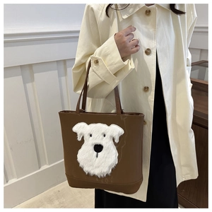 Brown leather tote bag featuring a cute white plush puppy patch shown on a model's shoulder